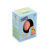 Angled view of a boxed capybara hatching egg toy, displaying a peach coloured egg through a window on the light blue and green package. The box features cartoon illustrations of a capybara hatching from an egg and instructions for placing the egg in water.