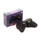 Angled view of a black stretchy stress fidget toy in the shape of a game controller with colourful yellow, green, red, and blue buttons. It is presented beside its dark purple retail box, which features pixelated game graphics, a clear window, and text reading 'GAME OVER' and 'I'M STRETCHY'.