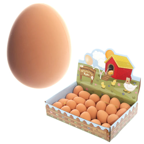Angled studio shot of a prominent brown novelty bouncing rubber egg, displayed alongside a retail box filled with multiple farmyard-themed bouncing eggs.