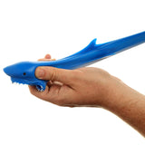 Close-up of a blue stretchy shark toy's head, being squeezed and stretched by a hand, revealing white teeth, a black eye, and a dorsal fin.