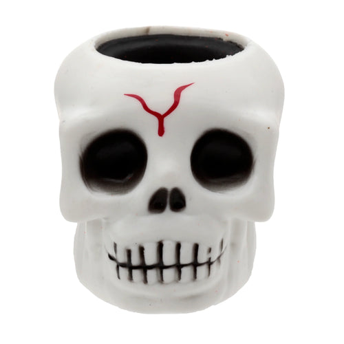 Front view of a white skull pop out toy, featuring black eye sockets, a black nose, a red Y-shaped mark on its forehead, visible teeth detailing, and a hollow black top.