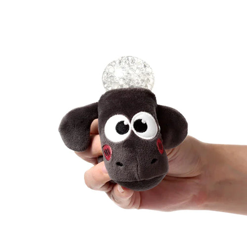 Close-up of a Queasy Squeezies Shaun the Sheep fidget toy, featuring its dark grey plush head with big white eyes, red embroidered cheeks, and a clear textured bubble on top, held in a hand.