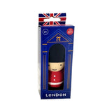 Angled front view of a stretchy Guardsman fidget toy in its blue display box with a Union Jack hanger. The toy, visible through the box window, features a black bearskin hat, cream face, and red uniform with white buttons. 'LONDON' is printed at the base of the box.