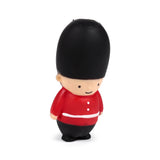 Angled view of a red and black stretchy guardsman fidget toy, featuring a tall black bearskin hat, a red uniform with white trim, and a light-coloured smiling face.