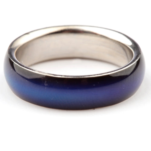 Close-up, angled view of a mood ring with a broad, dark blue outer band showing varied lighter blue tones, and a metallic silver-coloured inner band.