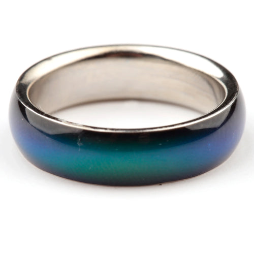 Close-up, angled view of a broad band mood ring, displaying a colour gradient of blue, teal, and green, with a silver-coloured interior.