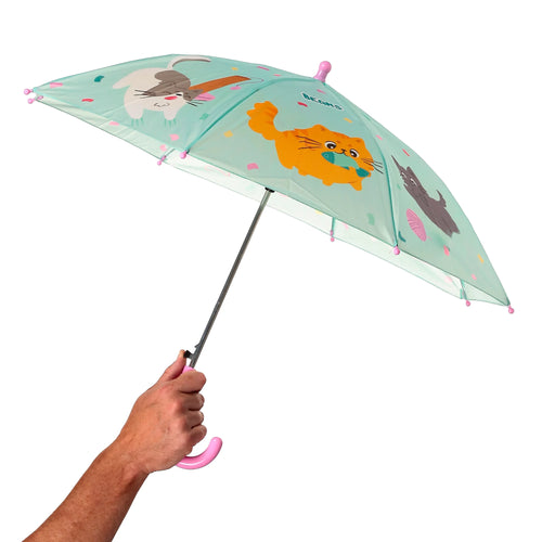 Kids' umbrella with mint green canopy depicting cartoon cats: an orange cat holding a fish, a grey and white cat, and a dark grey cat. It features a pink curved handle and pink safety tips, shown open and held by a hand.