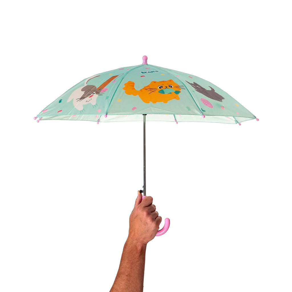 Kids' umbrella with mint green canopy decorated with colourful cat illustrations and 'Beans' text, featuring a pink crooked handle, held open by a hand.