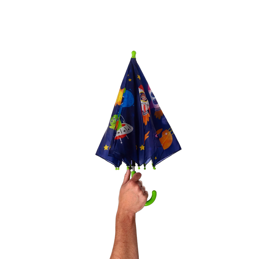 Angled view of a child's dark blue umbrella with a space cadet design featuring rockets, planets, and stars, held by a hand gripping the bright green curved handle.
