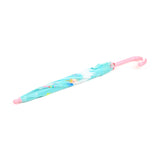 Angled view of a closed kids' umbrella, showing a light blue canopy with colourful pastel patterns, a pink hooked handle, and a pink rounded tip.