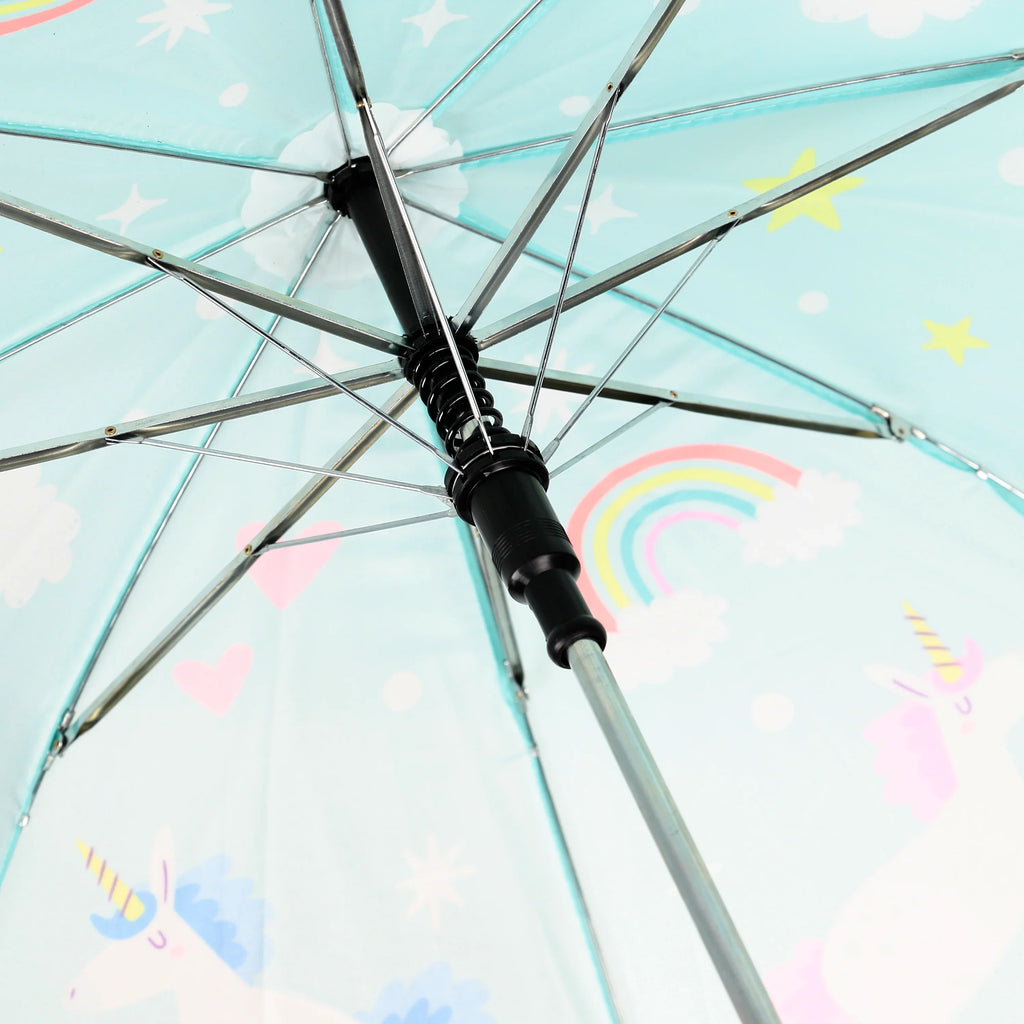 Close-up of the interior of a kids' umbrella, seen from underneath, showing its metal frame and black mechanism. The light blue canopy features a colourful unicorn, rainbow, stars, clouds, and heart pattern.