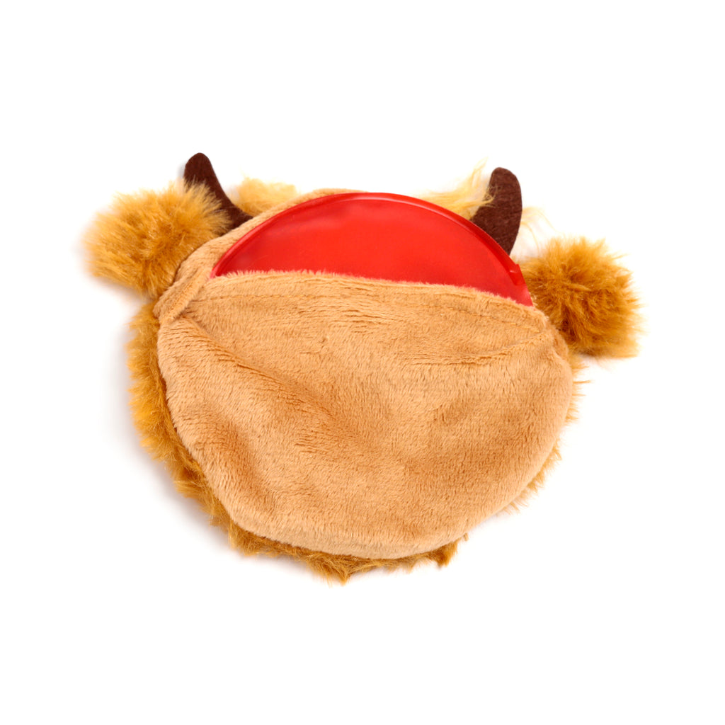 Overhead view of a plush Highland Coo hand warmer, featuring soft camel-coloured fur, small dark horns, and a visible red warming disc.