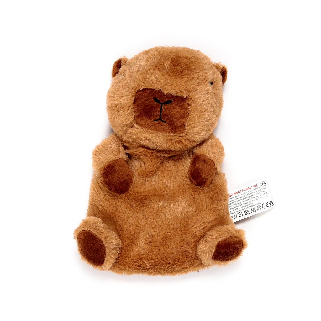 Fluffy brown capybara heat pack, with darker brown embroidered snout, small ears, paw patches, and a visible white care label.