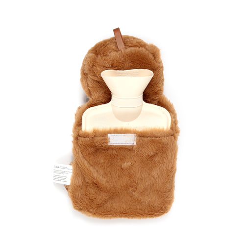 Overhead view of a brown fluffy plush hot water bottle, showing its cream-coloured rubber neck and opening. A small brown fabric loop is attached at the top, and a white fabric care label hangs from the left.