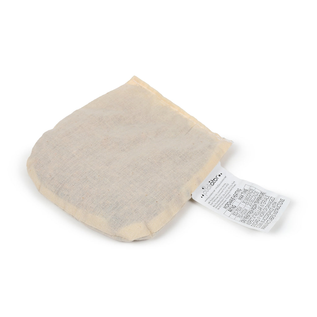 Angled view of a cream-coloured fabric microwavable heat pack pouch, featuring a white label with heating instructions.