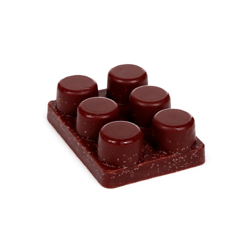 Angled view of a dark brown, rectangular wax melt block with six glossy, dome-shaped melts and a subtle speckled texture on its base.