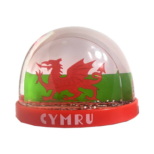 Front view of a collectable snow globe featuring a red Welsh dragon against a white and green flag background inside, with 'CYMRU' in white letters on its red base and internal particles simulating snow.
