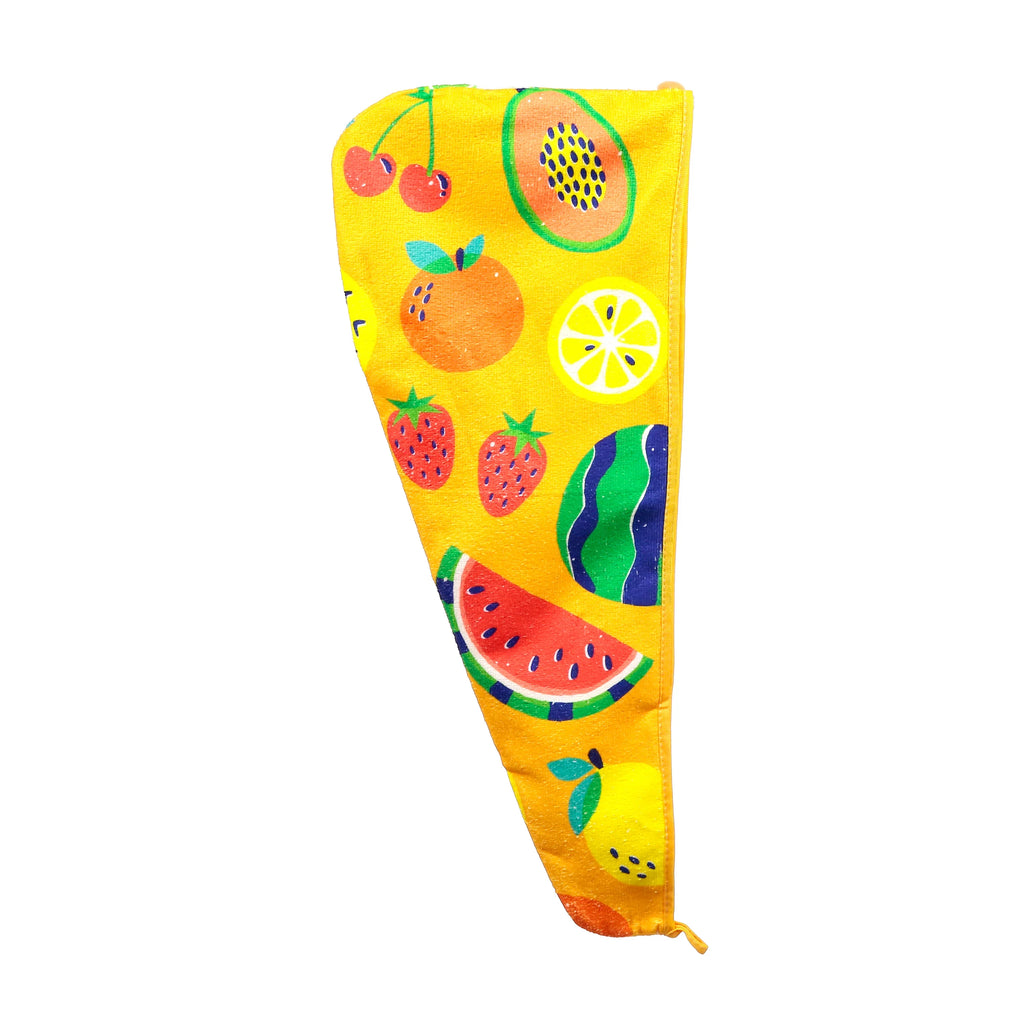 Flat lay of a yellow hair wrap towel, featuring a colourful summer fruits pattern including cherries, papaya, oranges, lemons, strawberries, and watermelon.