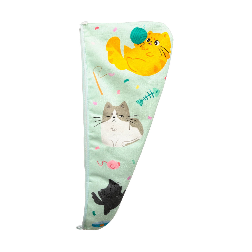 Mint green hair wrap towel, laid flat, featuring a cute cat design. The towel showcases a yellow cat playing with a green yarn ball, a winking grey and white cat, and a black cat, all amidst scattered colourful confetti and cat toys. A white elastic loop is visible at the top.