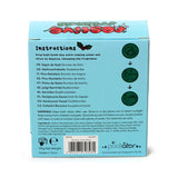 Rear view of a light blue Christmas tree bath bomb gift box, showcasing detailed usage instructions, ingredient information, and a 110g net weight label.