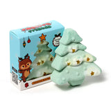 Front view of a green Christmas tree shaped bath bomb with gold stars, next to its light blue gift box featuring a clear tree-shaped window.