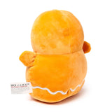 Back view of an orange plush gingerbread man toy, showing wavy white icing detail and a care label.