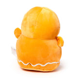 Back view of an orange gingerbread man plush toy, featuring white wavy icing detail along the bottom and a care tag on the side.