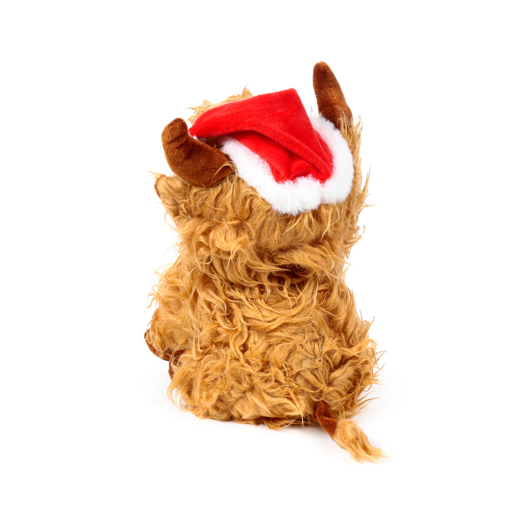 Angled rear view of a plush Christmas Highland Coo door stop, featuring shaggy light brown fur, small brown horns, and a red Santa hat with a white fluffy trim.