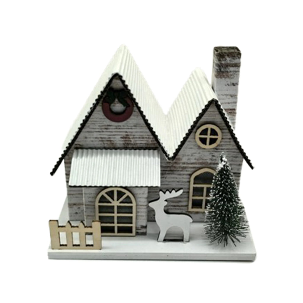 LED Silver Birch Double Fronted Christmas House decoration, featuring white corrugated roofs, arched windows, a festive wreath, a white reindeer figure, and a miniature Christmas tree, all set on a snowy white base, shown from an angled perspective.