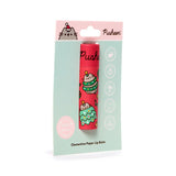 Front view of a red paper stick lip balm, decorated with festive cartoon cats dressed as Christmas trees, displayed on a mint green backing card. The packaging features a 'Zero Waste' label and mentions 'Clementine' flavour.