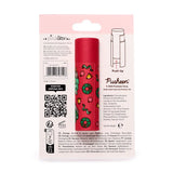 Back of a Christmas Pusheen the Cat paper stick lip balm on its white retail packaging. The red lip balm stick is decorated with green festive wreaths, bells, baubles, and a light blue Pusheen cat wearing a Santa hat. Visible on the packaging are 'Push Up' instructions, an ingredients list, and multilingual descriptions for an orange-scented, zero-waste lip balm.