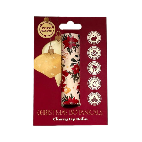 Front view of a paper stick lip balm in a Christmas botanicals design with red poinsettias and holly, displayed on a red backing card. The card features 'Cherry Lip Balm' text and icons indicating zero waste, vegan, cruelty-free, palm oil free, and plastic-free benefits.