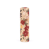A paper stick lip balm, standing upright, featuring a Christmas botanicals design with red poinsettias, green holly, white mistletoe berries, candy canes, and gold baubles on a kraft-coloured background.