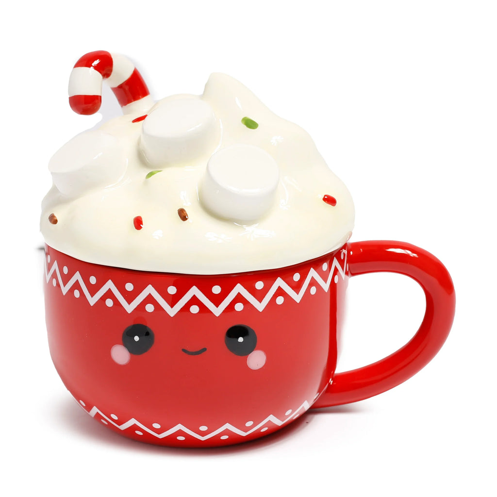 Angled view of a red ceramic lidded mug with a cute smiling cartoon face, pink cheeks, and white zigzag patterns. The white lid mimics whipped cream, adorned with white marshmallows, colourful sprinkles, and a red and white striped candy cane.
