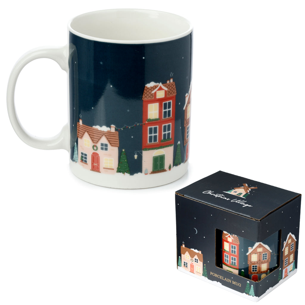 Angled view of a Christmas Village Porcelain Mug, showcasing its dark blue design with colourful snowy houses and festive trees. The white handle and interior are visible, alongside its matching dark blue packaging box.