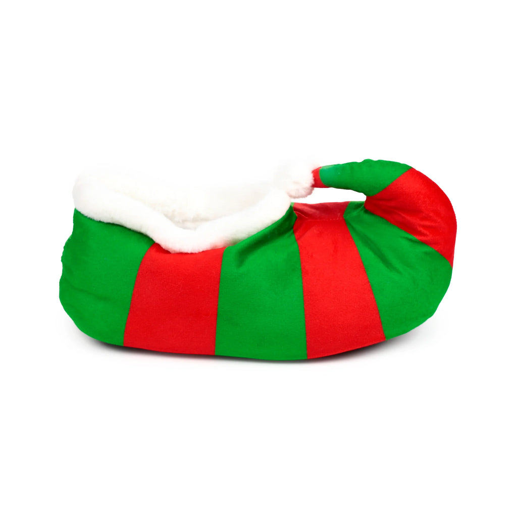 Angled view of a red and green striped plush elf slipper with a curled toe, white fluffy trim, and a white pom-pom.
