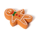 Angled view of a Christmas gingerbread man stretchy stress fidget toy, featuring white icing details, red buttons, and a green bow tie on a white background.