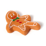 Front view of a brown stretchy gingerbread man fidget toy with white icing details, red buttons, a green bow tie, and a smiling face, set against a white background.