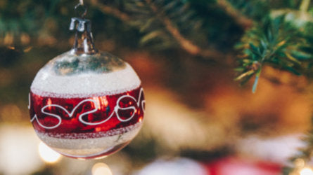 Background image of a bauble hanging from a Christmas tree branch 