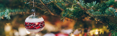 Background image of a bauble hanging from a Christmas tree branch 