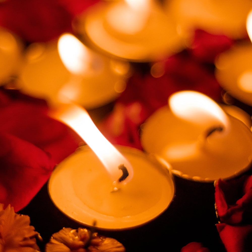 Candlelight scene with blurred candles and flowers in the foreground