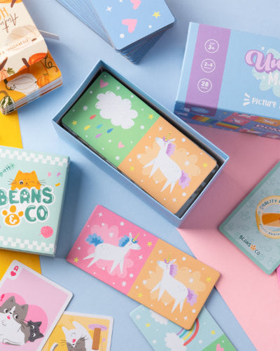 Colourful children's picture dominoes cards and boxes on a blue and pink background

