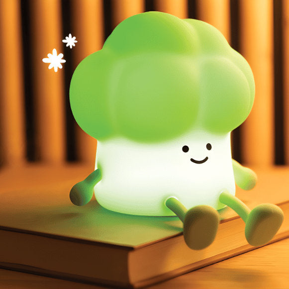 Green broccoli-shaped night light on a book with a warm background