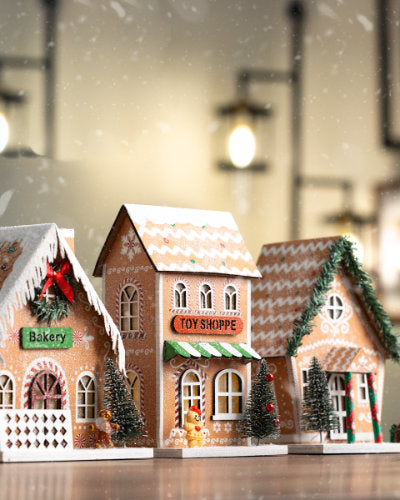 Whimsical gingerbread-style houses with Christmas decorations and 'Toy Shoppe' and 'Bakery' signs on a blurred background.