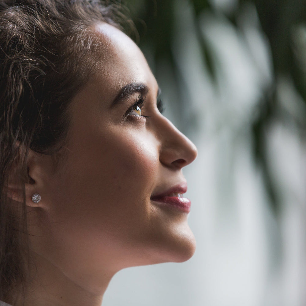 Close-up of a woman's profile with a blurred natural background