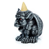 Angled view of a dark grey stone-effect gargoyle backflow incense burner, with striking red eyes, an open mouth, and a beige incense cone resting in a silver-coloured holder on its head.