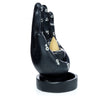 Angled view of a black hand-shaped backflow incense burner, detailed with white zodiac and planetary symbols on its palm and fingers, holding a light brown incense cone, on a circular base.