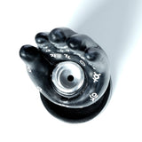 Overhead view of a dark hand-shaped backflow incense burner, featuring a silver-coloured cone holder in the palm and white mantric symbols detailing the fingers and palm.