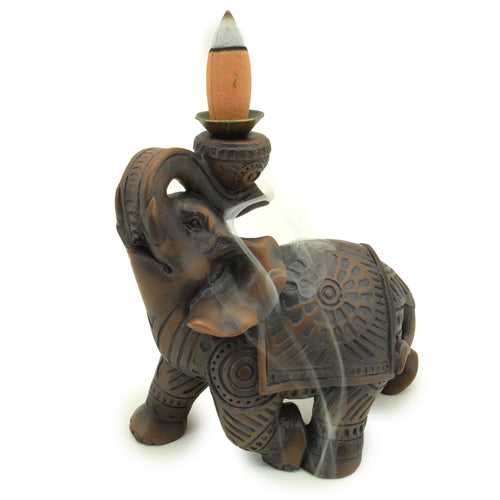 Decorative elephant incense burner with a lit incense stick on a white background