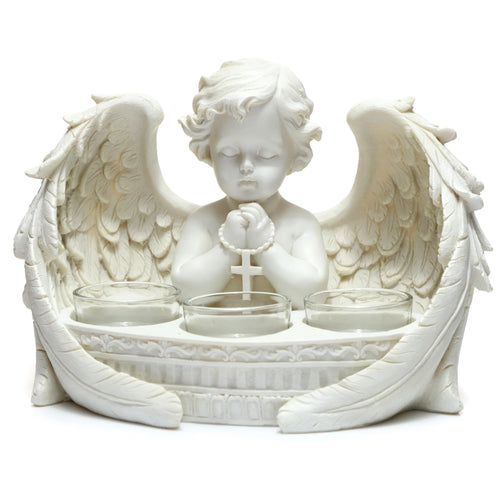 Front view of a white cherub tea light holder. The winged cherub, with curly hair and eyes closed in prayer, holds a rosary with a cross. Three clear glass tea light holders are set into the ornate base.